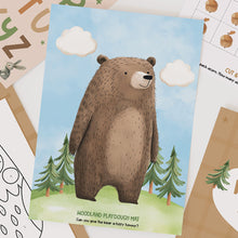 Load image into Gallery viewer, Woodland-themed playdough mat with a bear illustration on a surface with other educational materials.