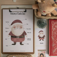 Load image into Gallery viewer, Christmas-themed items including a book titled 'A Treasury of Christmas Stories' and educational chart about Santa Claus on a wooden surface.
