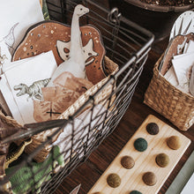 Load image into Gallery viewer, Printed educational activity sheets and materials arranged in a basket, themed around dinosaurs and paleontology, including coloring sheets, matching cards, and lacing cards.
