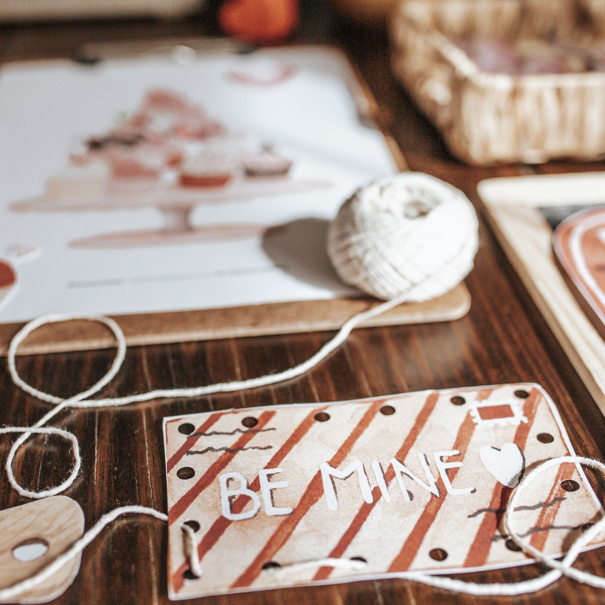 Valentine's Day card with 'BE MINE' text on a wooden surface